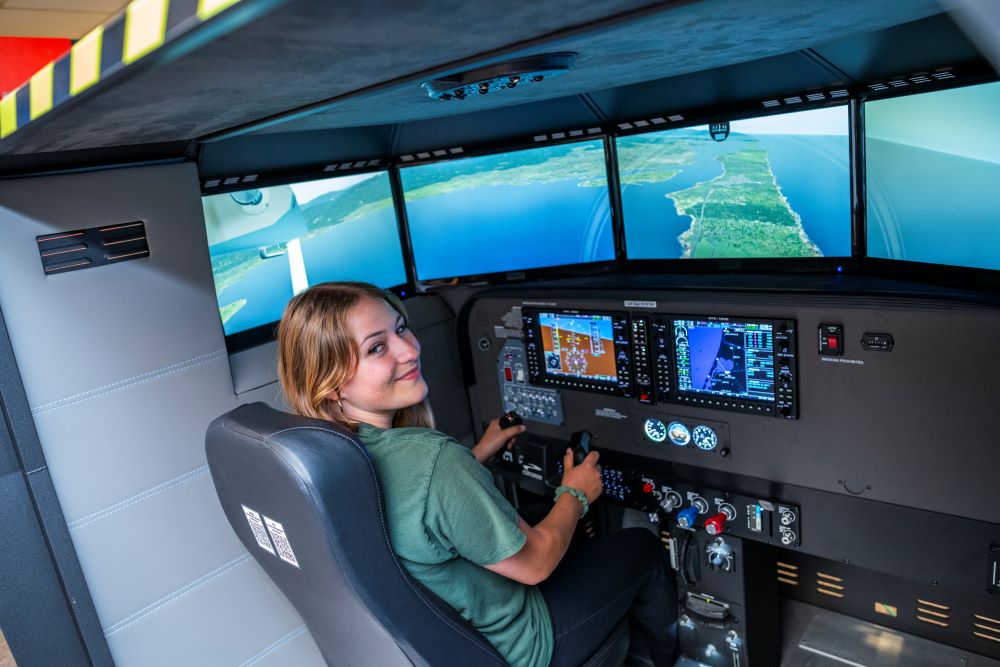 A photo of Humboldt student Harmony Switzer Tryon using the flight simulator at the Library. 