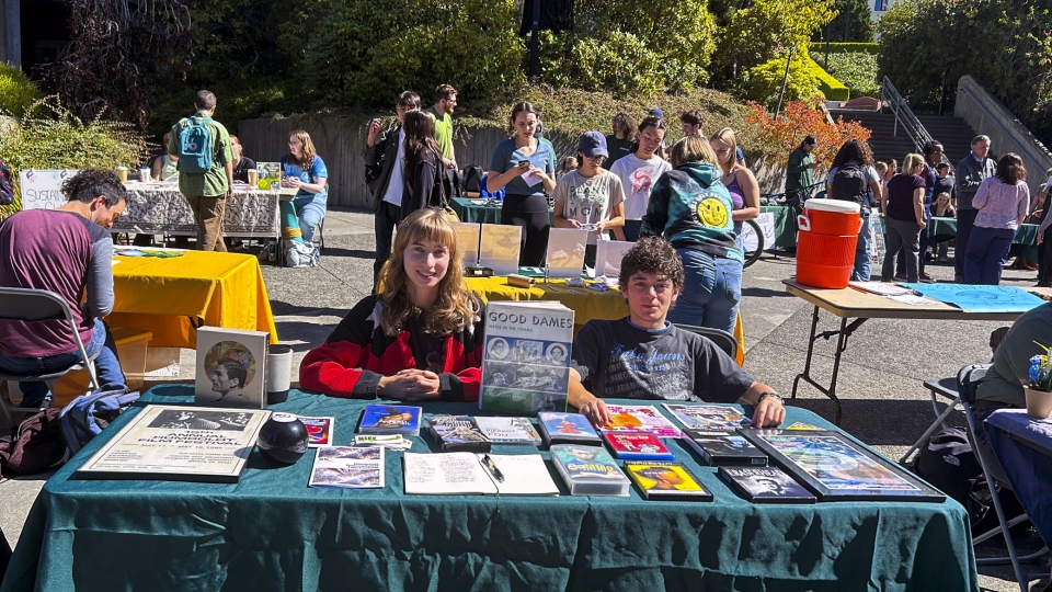 Two cinema club members tabling on the University Quad during a clubs fair.