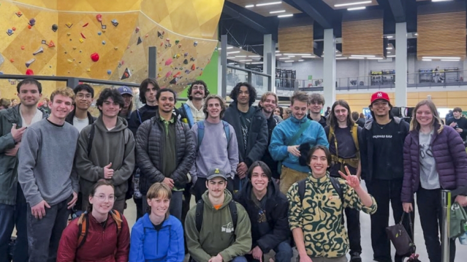 A group photo of the climbing club in a climbing gym. 