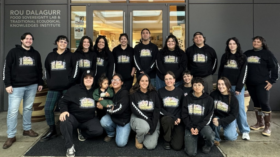 A large group of students in black sweatshirts in front of the Food Sovereignty Lab