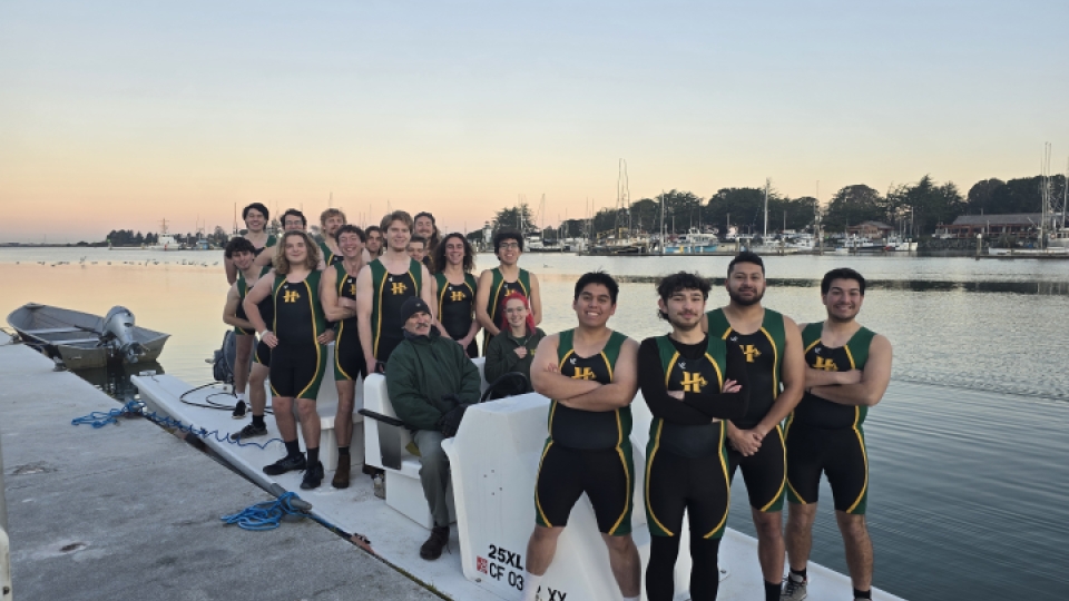 Men's crew club team standing on the dock.