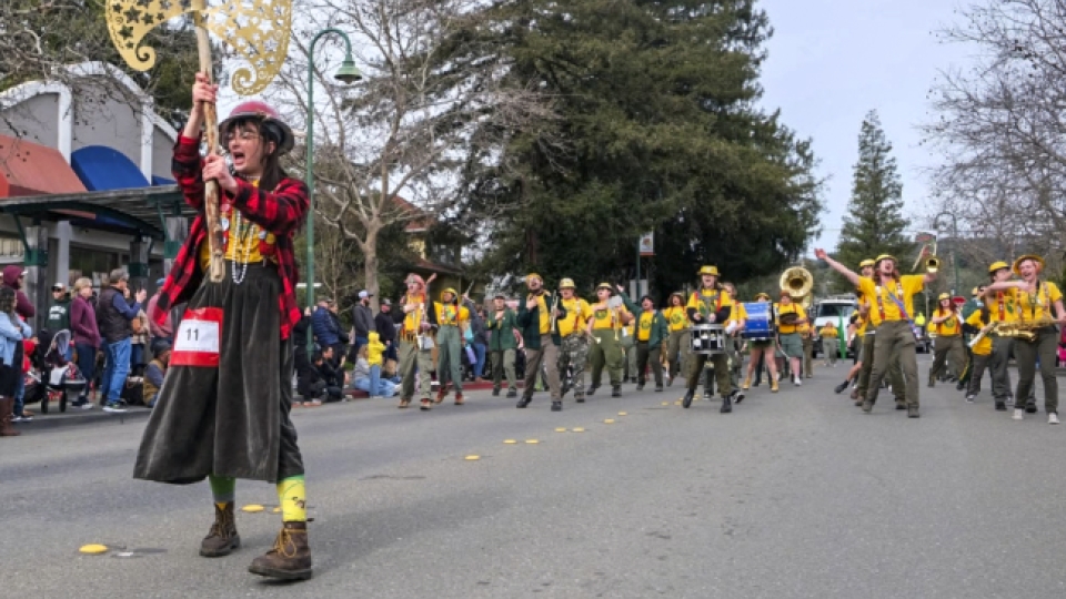 The Marching Lumberjacks and axe major marching in a parade.