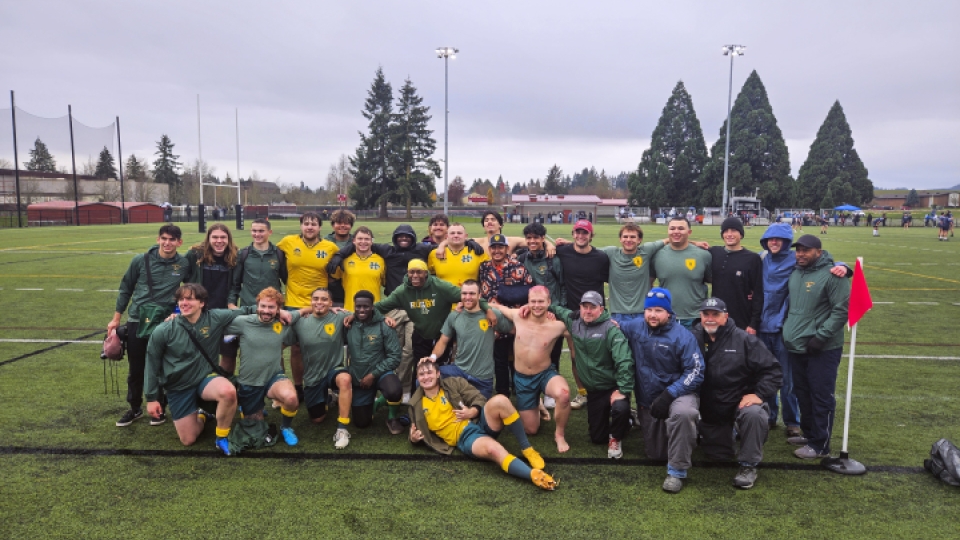 A rugby team photo after a game on the field.