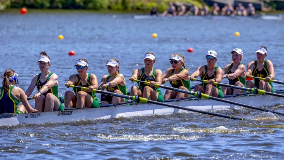 women's crew team in the 8 person boat, rowing.