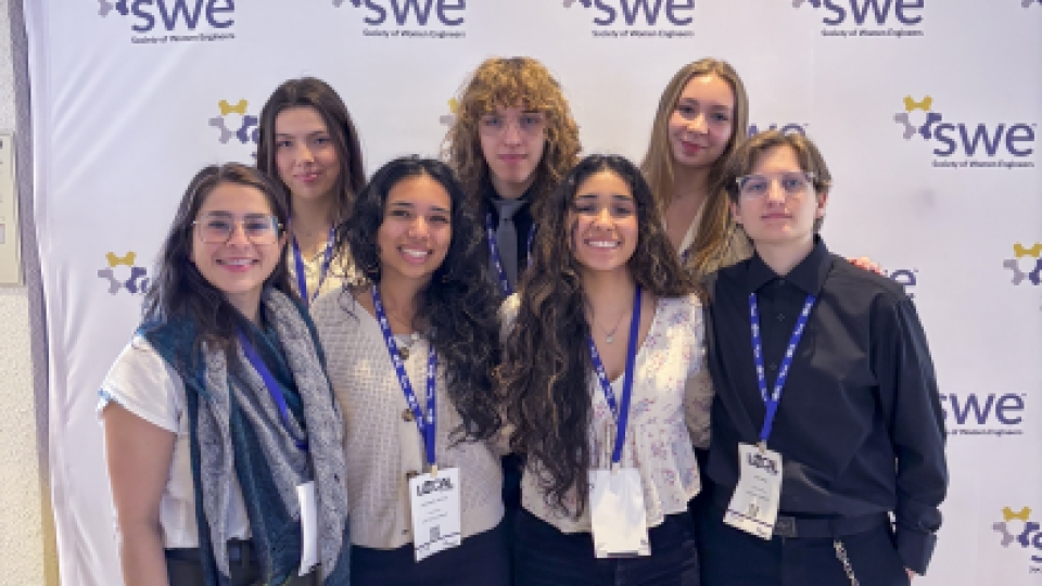 A group photo of women engineers at a conference in professional clothing.