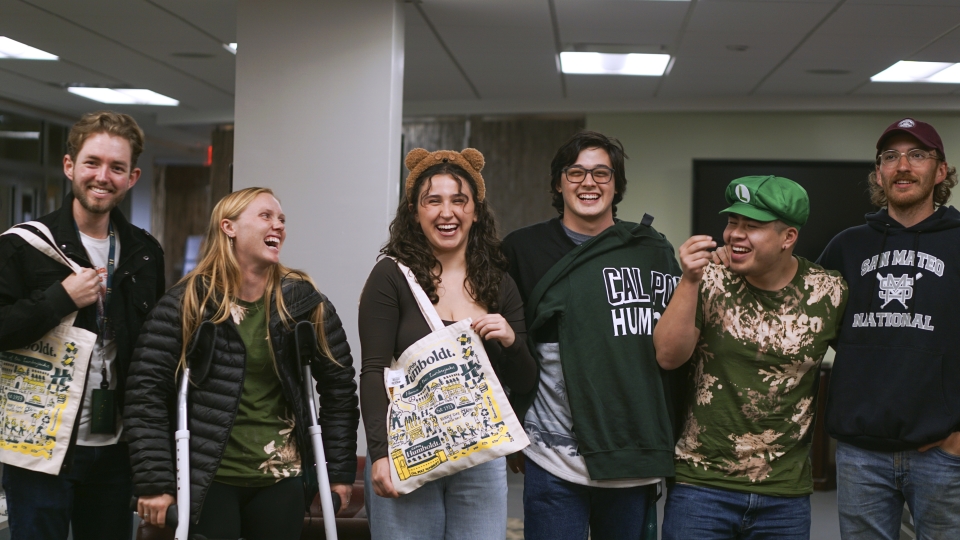 Six transfer students laughing inside of building.